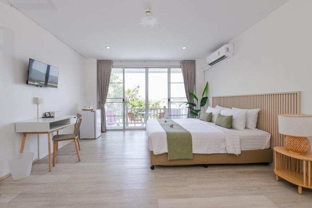 a bedroom with a large bed and a desk and a table at Little Home Ao Nang in Ao Nang Beach
