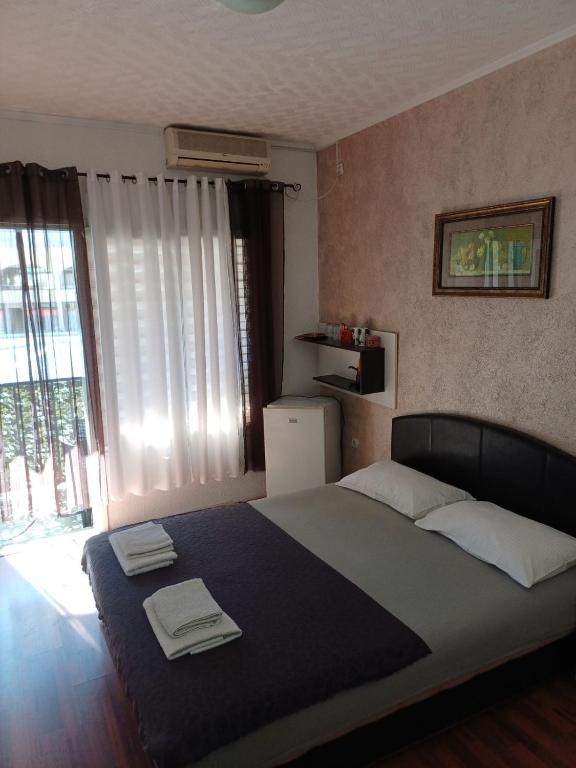 a bedroom with a large bed with two towels on it at Room Rada in Ulcinj