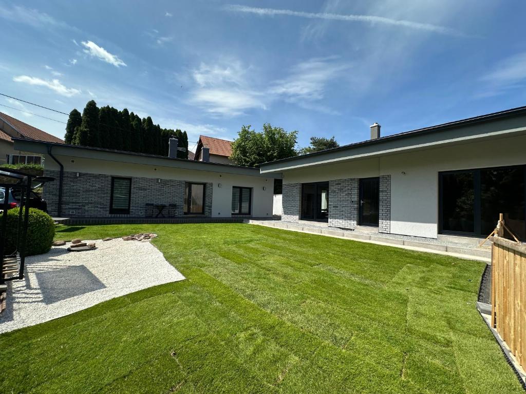a backyard of a house with a green lawn at Apartmány Krymlov in Oleška