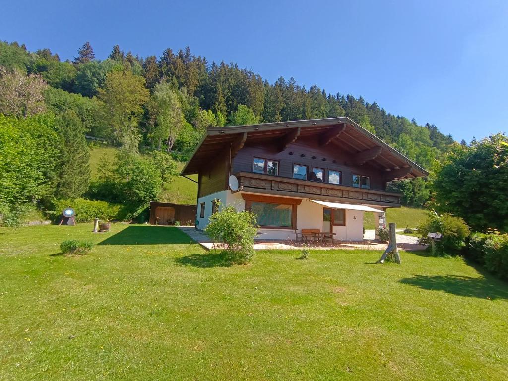 a house on a hill with a grass yard at Landhaus Rieder in Mittersill