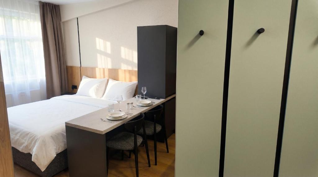 a hotel room with a bed and a table and chairs at Axiom Suites - Nova 4 in KoÅ¡ickÃ© KÃºpele