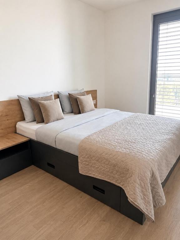 a large bed in a bedroom with a white wall at Harmony Metropolis Bratislava Free Parking in Nivy
