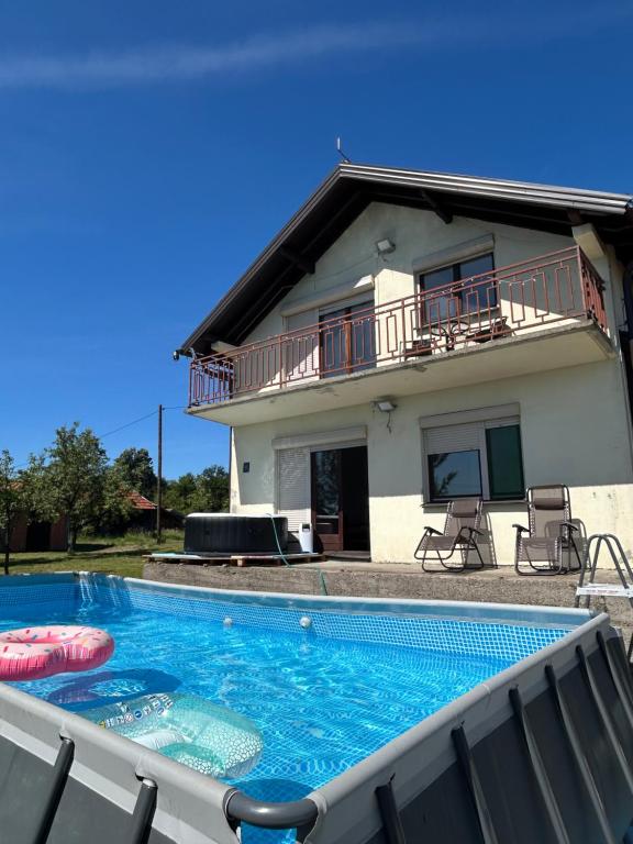 a villa with a swimming pool in front of a house at Breze Away in Tuzla