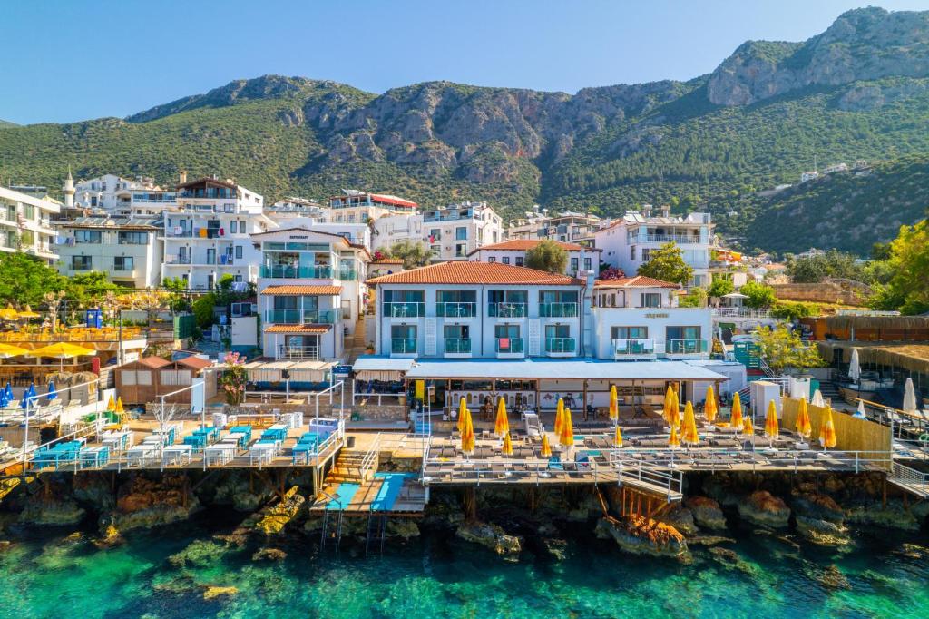 a view of a resort on the water with chairs and umbrellas at The Kaş Otel in Kaş