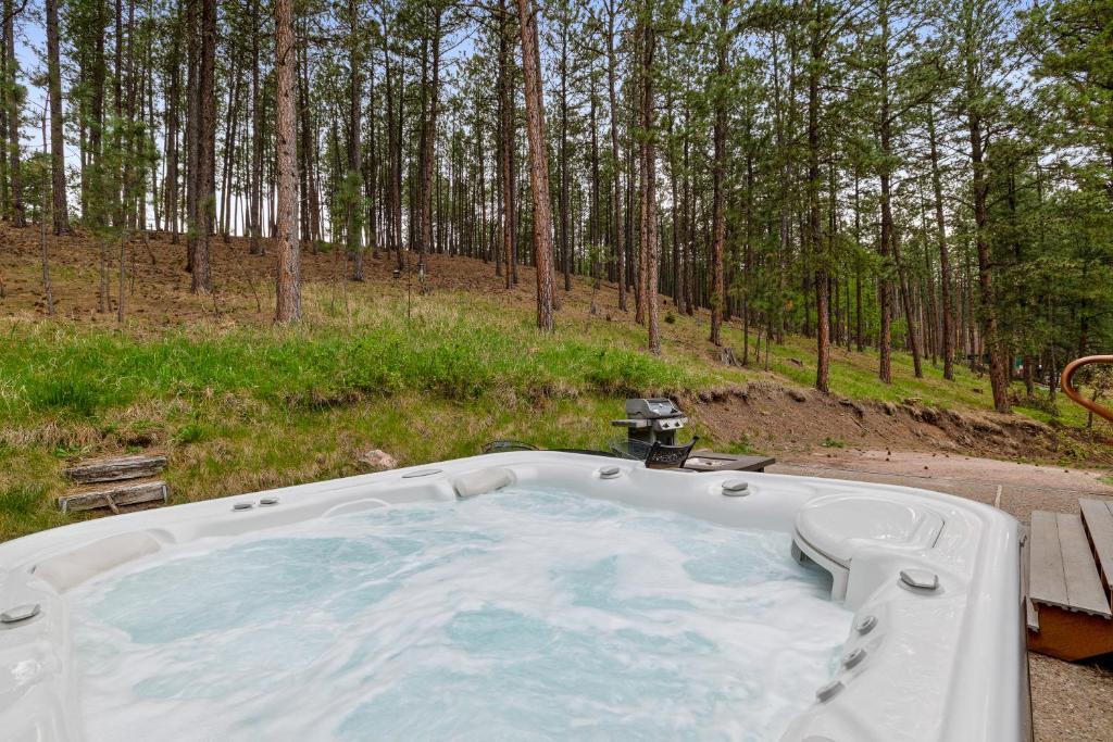 a hot tub in the middle of a forest at Prairie Creek Cabin Getaway in Rapid City