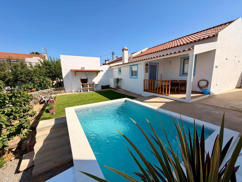 a villa with a swimming pool and a house at Casinha do Cercal in Cercal