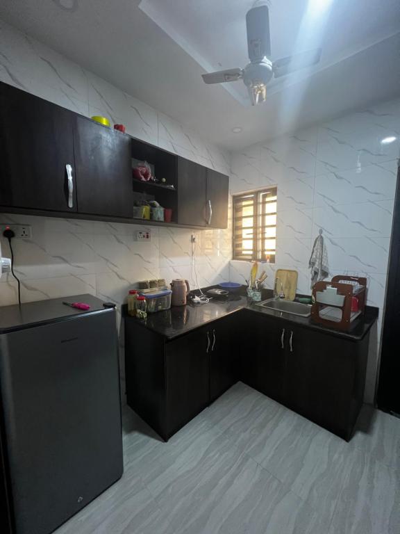 a kitchen with black cabinets and a counter top at Private Bedroom with a private bathroom in Bolorunpelu