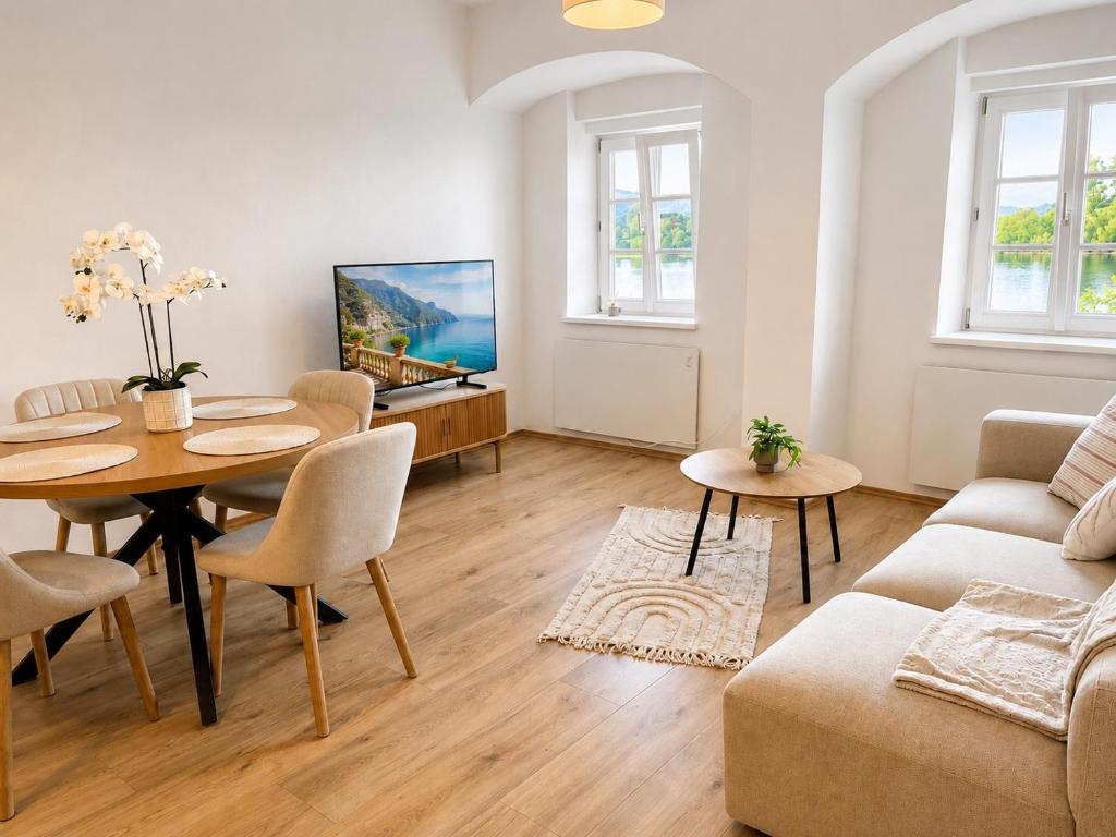 a living room with a table and a couch at Riverside Ybbs - Danube View in Ybbs an der Donau