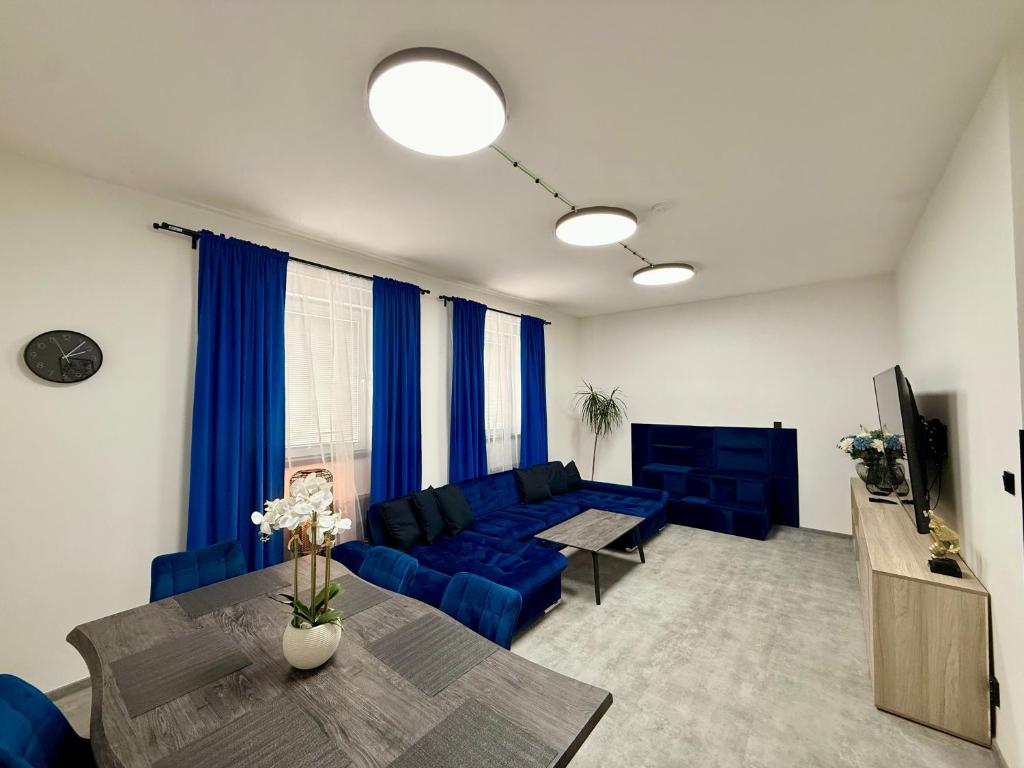 a living room with a blue couch and a table at Teplice Apartments in Teplice