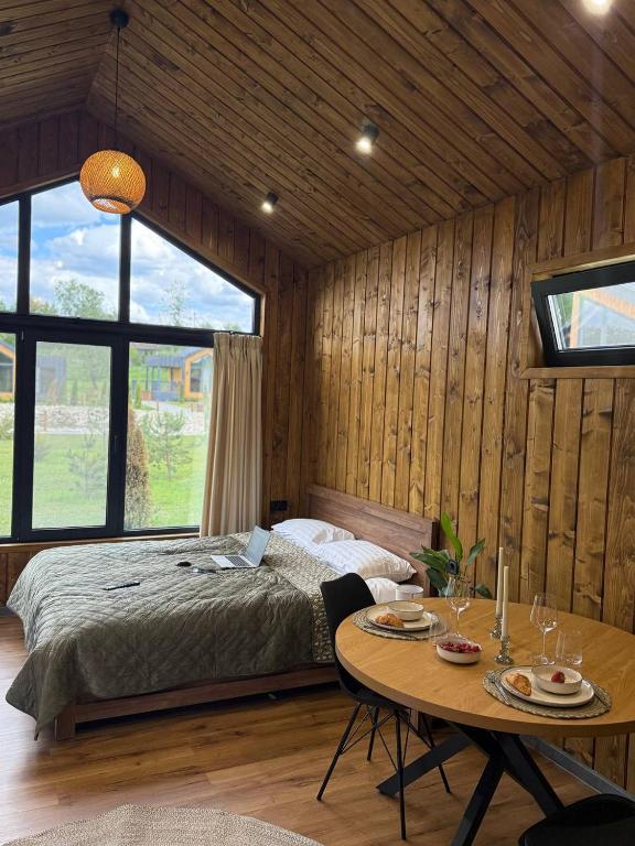 a bedroom with a bed and a table at Sosna Park Будиночки in Vynnychky