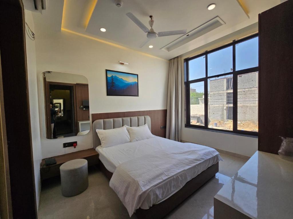 a bedroom with a bed and a large window at Shree Radha Raman Sarkar Dham in Vrindāvan