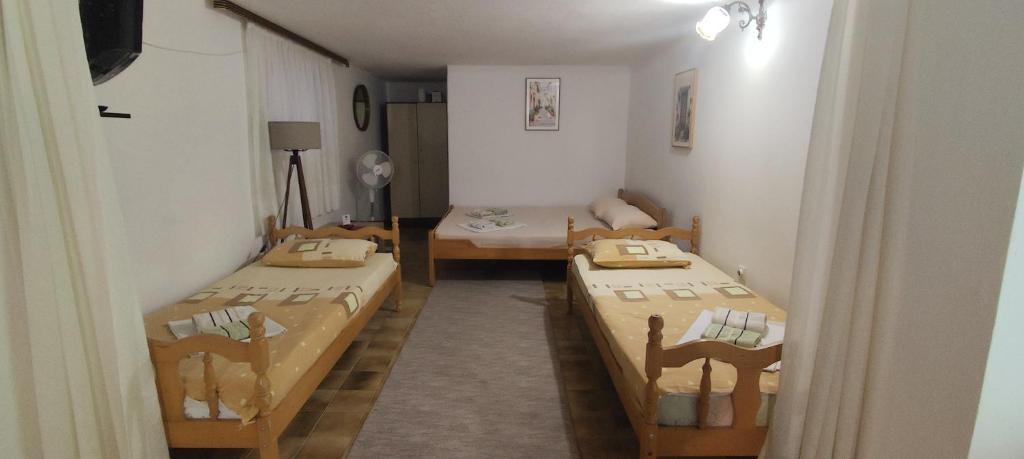 a room with three beds in a room at Apartmani Vučević in Sutomore