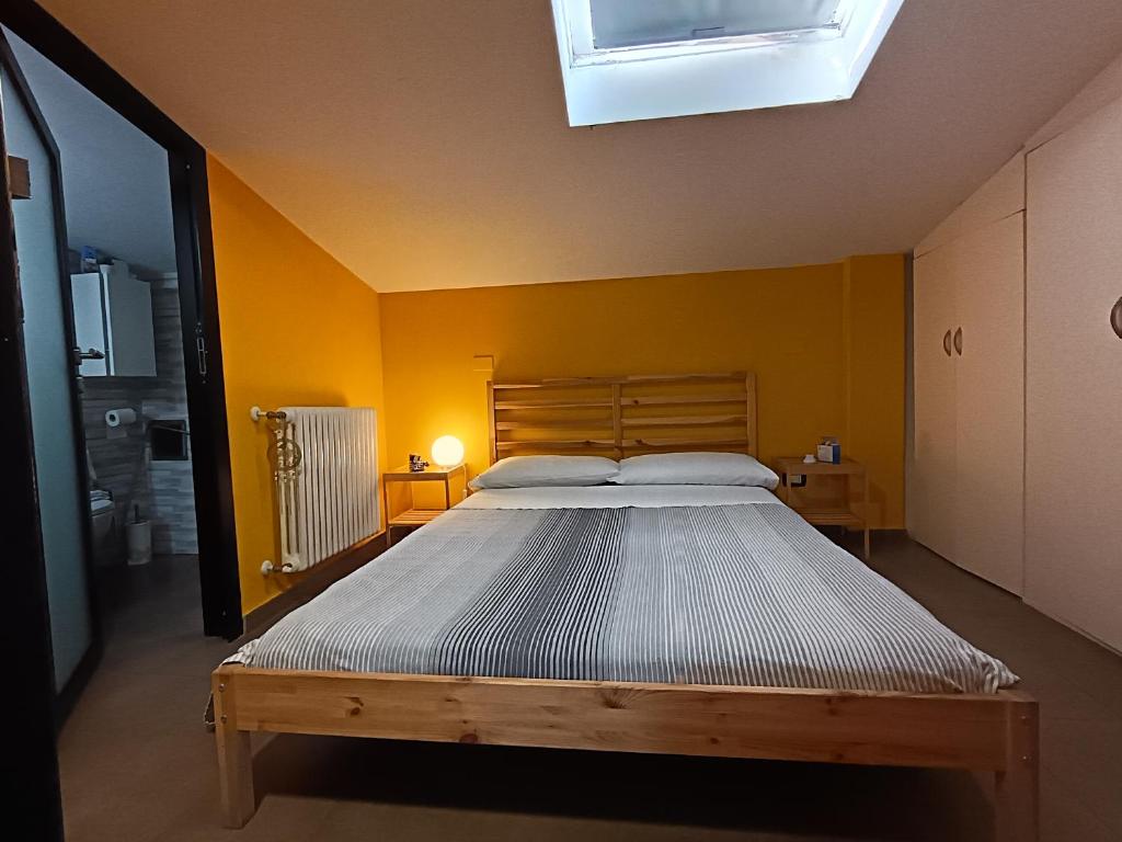 a bedroom with a large bed in a yellow wall at Solaris Guest House in Ciampino
