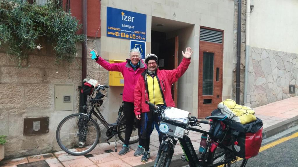 two men are standing next to their bikes at Albergue Izar in Viana