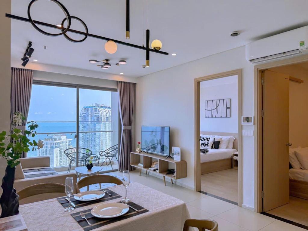 a living room with a dining table and a living room with a view at Căn hộ The Song Du lịch biển Tháp Tam Thắng INFINITY POOL FREE IN SIDE THE SEA in Vung Tau