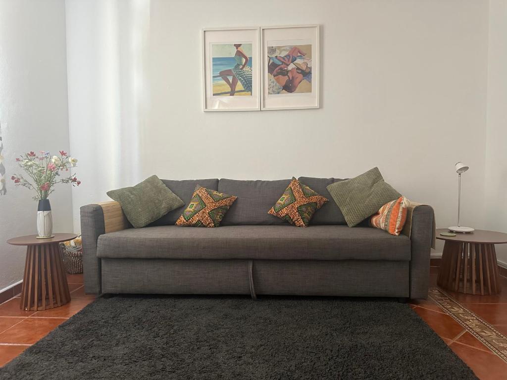 a living room with a gray couch and two tables at Central Tavira apartment, Casa Oliverio in Tavira