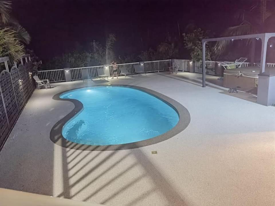 a swimming pool at night with a fence at Villa melys in Petite Île