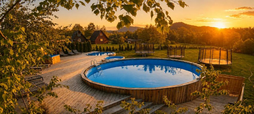 a hot tub in a yard with a sunset in the background at Agro Solina in Solina