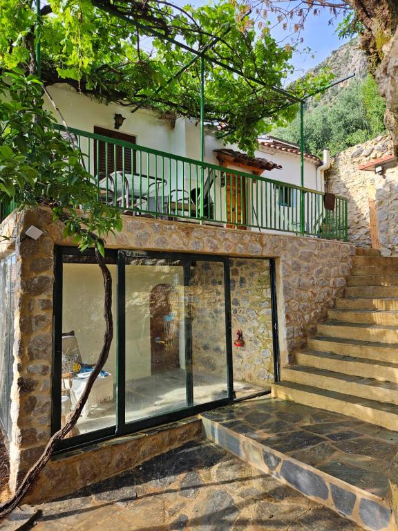 a house with glass doors and a balcony at Mount Kalathi Seaview Retreat in Verga Kalamata