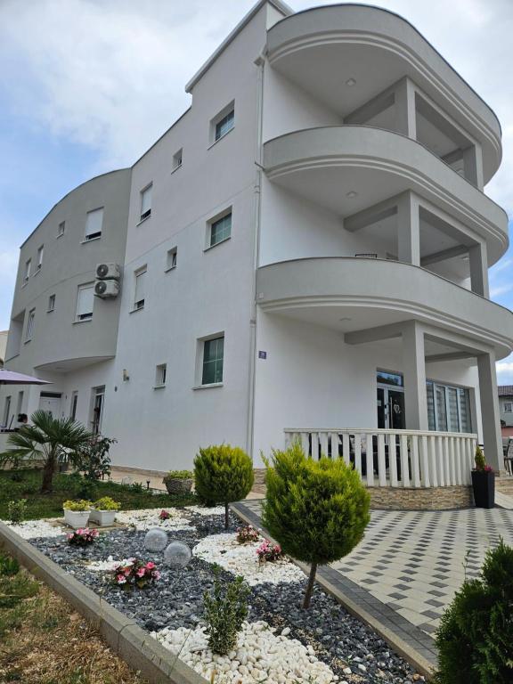 a large white building with some bushes in front of it at Pansion Milena i Mario in Međugorje