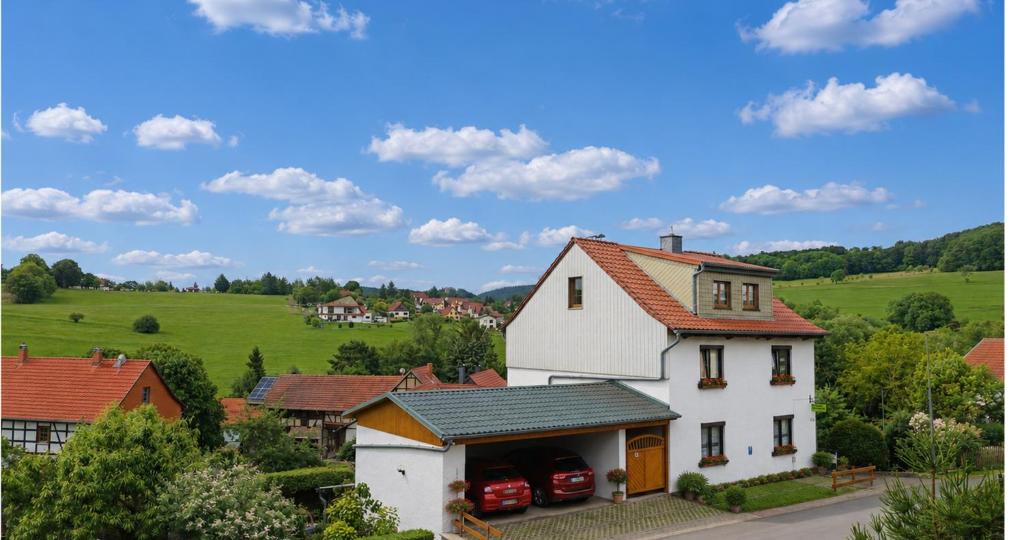 a white house with cars parked in front of it at Ferienwohnung Gute Zeit in Ruhla