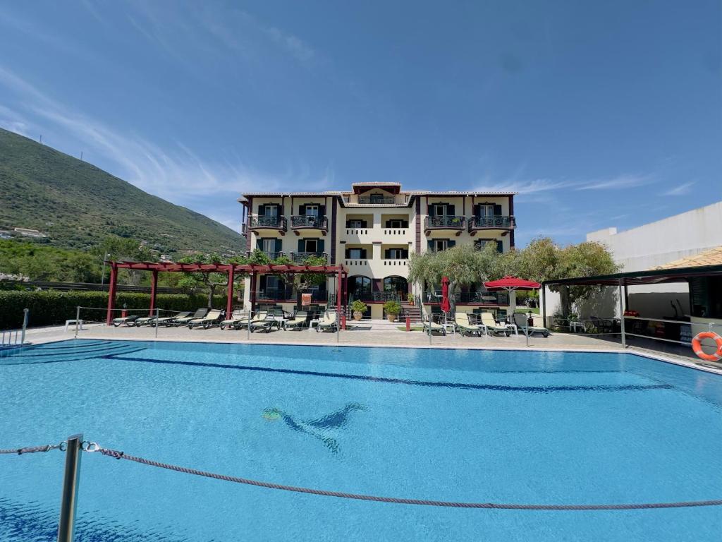 a swimming pool in front of a hotel at Porto Fico Hotel in Vasiliki