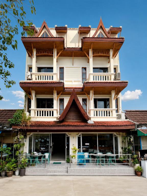 a tall building with tables in front of it at Holiday House Kata & Karon Phuket Hotel in Kata Beach