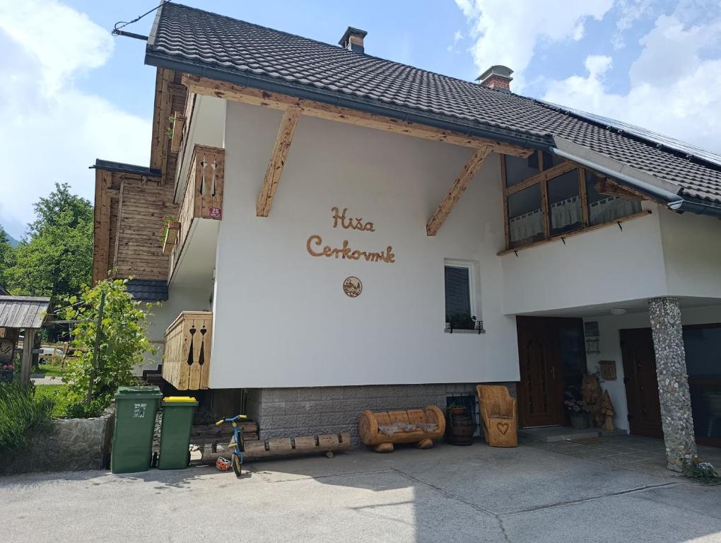 a white building with a sign on the side of it at Apartments and rooms Cerkovnik in Bohinj