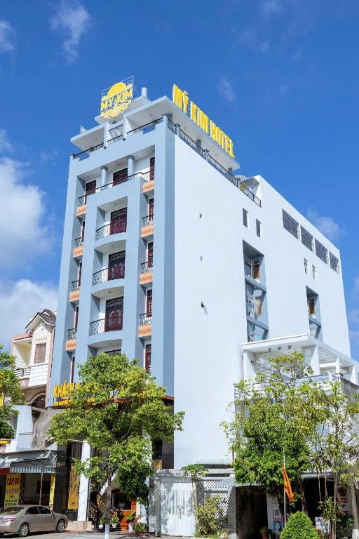 a white building with a sign on top of it at Khách Sạn Mỹ Kim in Cà Mau