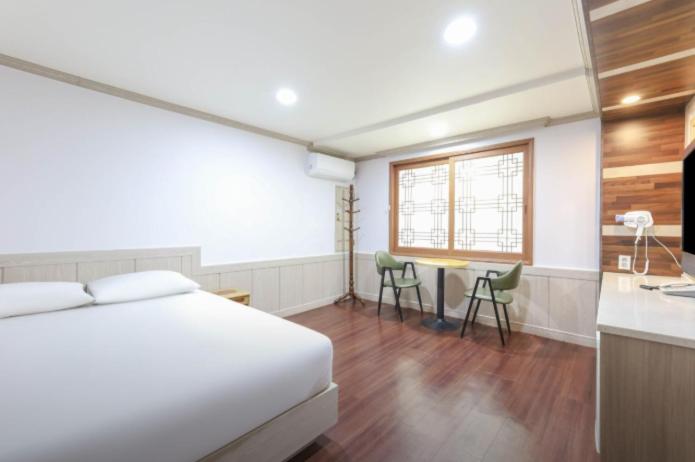 a bedroom with a bed and a table and a kitchen at 범어사 범어호텔 in Ch'ŏngnyong-dong