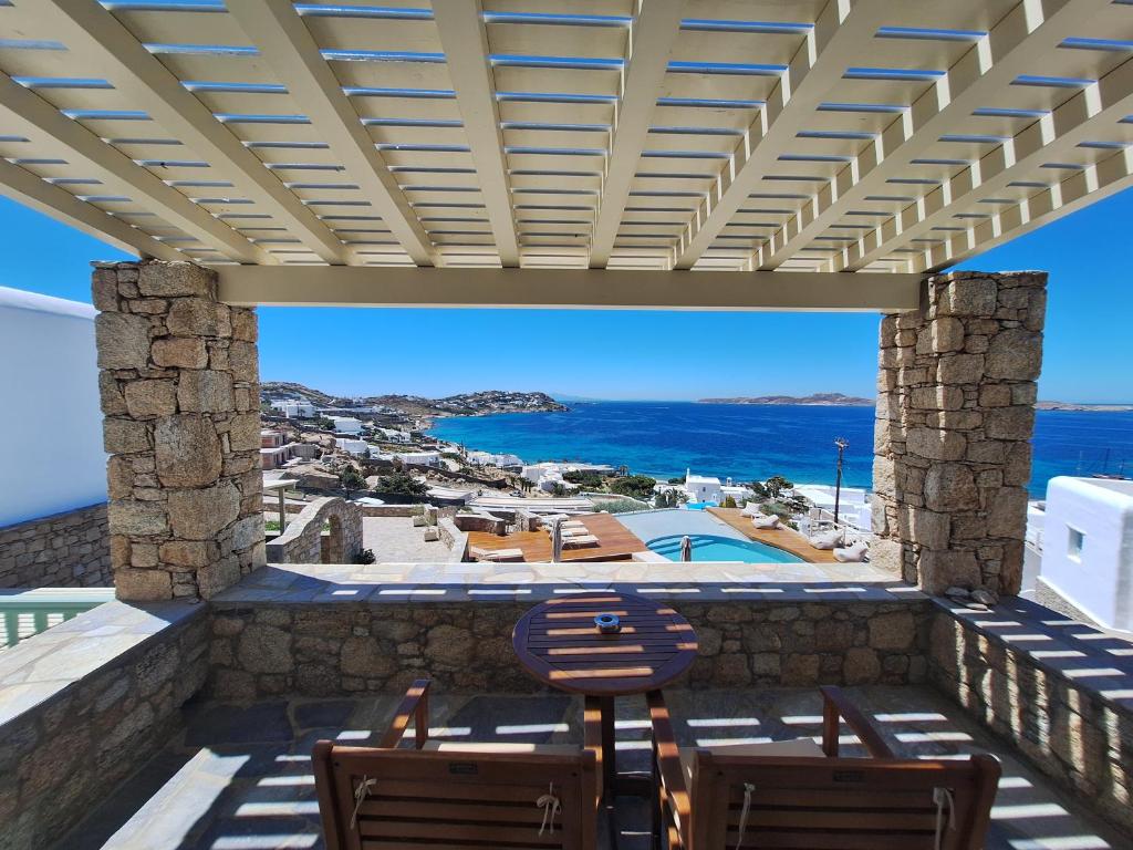 a patio with chairs and a view of the ocean at Panthea Residence in Agios Ioannis Mykonos