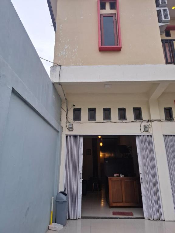 a hallway of a building with a door and a window at Penginapan 369 in Sentani
