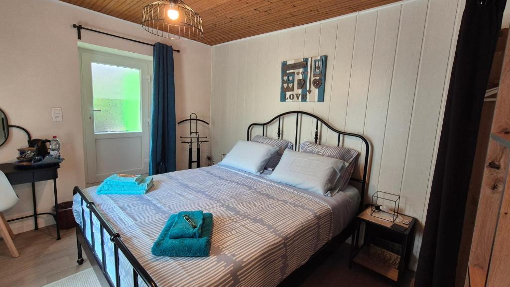 a bedroom with a bed with blue towels on it at Mon Refuge B&B in Jougne