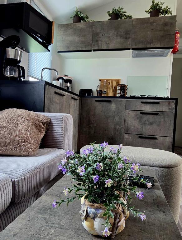 a living room with a table with flowers on it at Moon Lodge in Koksijde