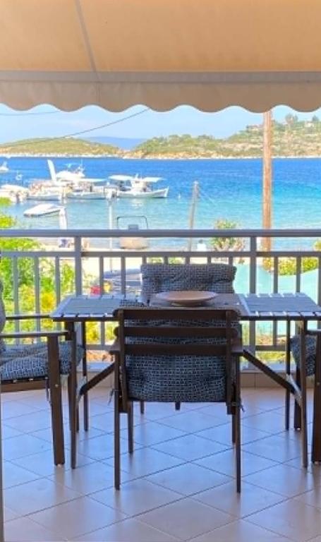 a table and chairs on a balcony with a view of the ocean at Sophies Apartments Ormos in Ormos Panagias