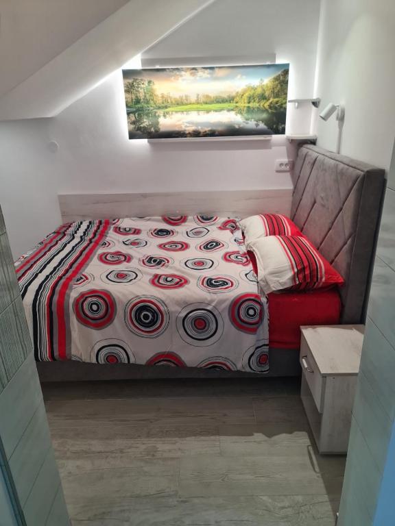a bedroom with a bed with a red couch at Apartman Angela in Igalo