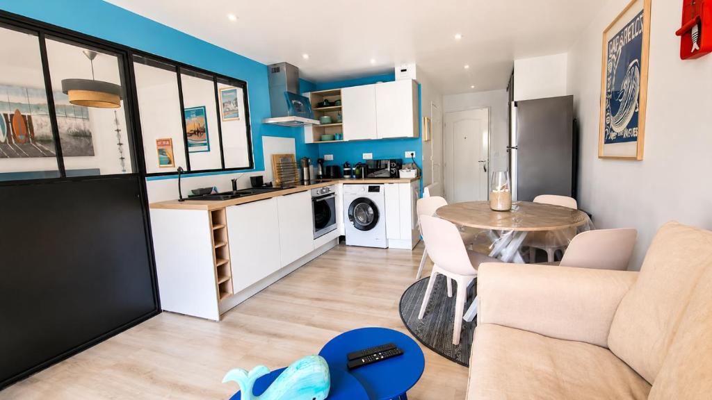 a kitchen and living room with a table and a couch at HOME ET HOLIDAY Le Chardonnay in La Baule