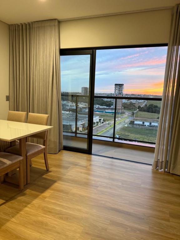a conference room with a table and a large window at Studio Liv in Sorriso