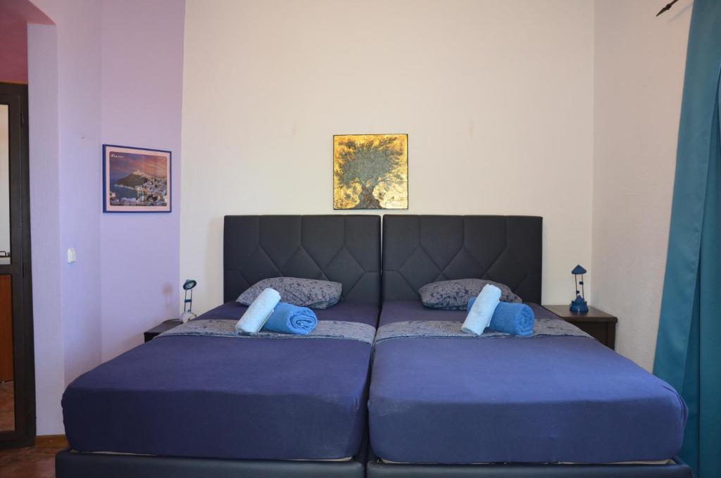 a large blue bed with blue pillows in a bedroom at Sunray Room for Two in Zagora in Zagora