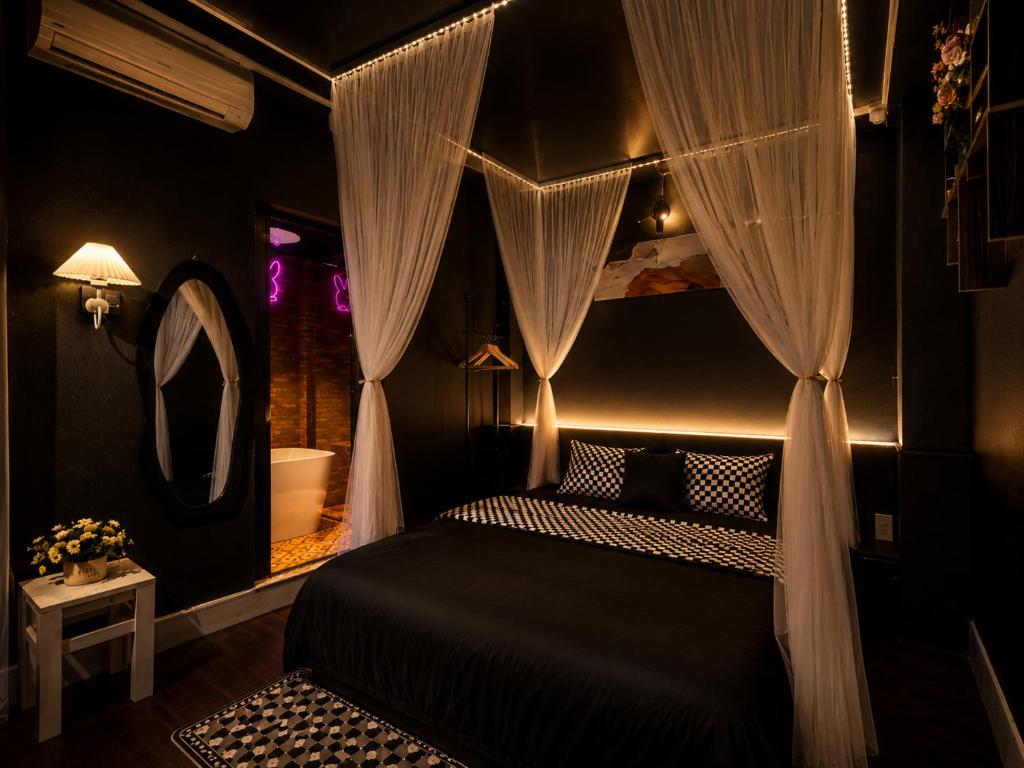 a bedroom with a bed with curtains and a mirror at Spring Home 2 in Can Tho