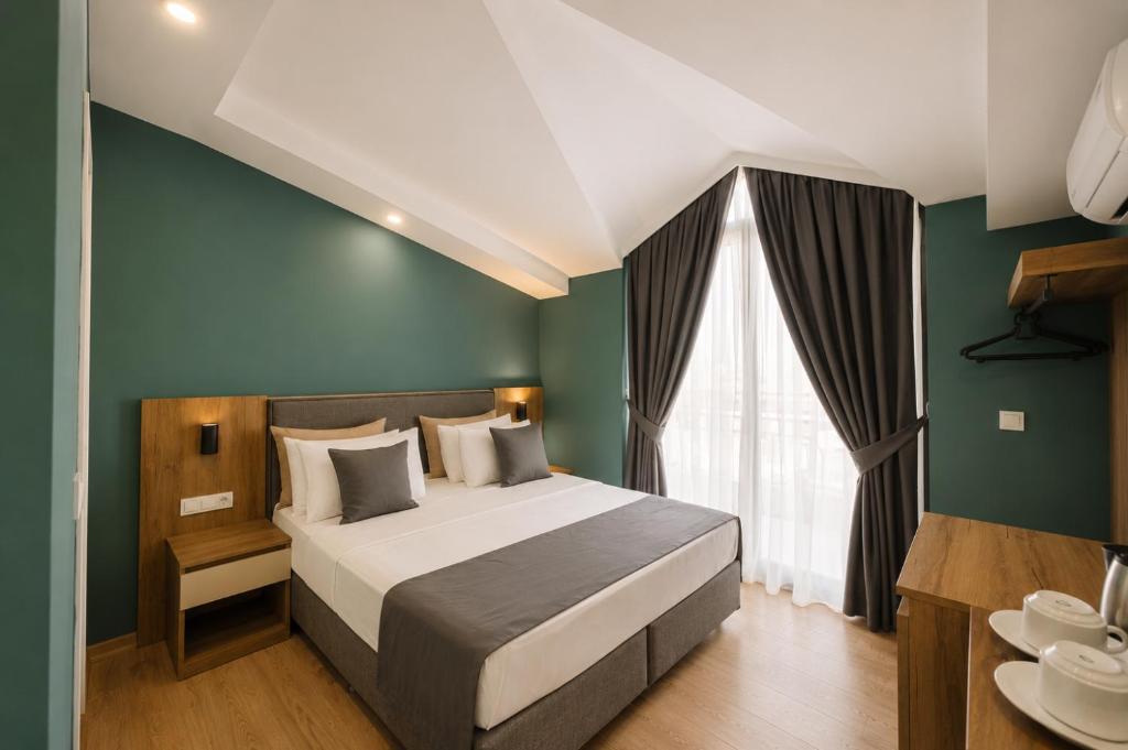 a bedroom with a bed and a green wall at Deniz Boutique Hotel in Antalya