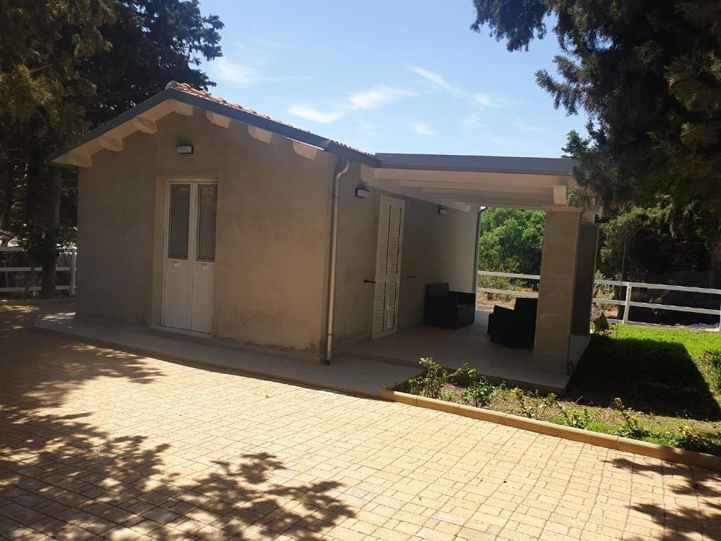 a small building with a porch and a driveway at Casa via maucini in Pachino