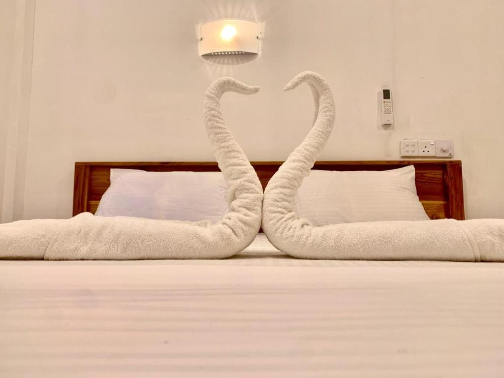 two swans made out of towels on a bed at Royal Palms Resort in Arugam Bay