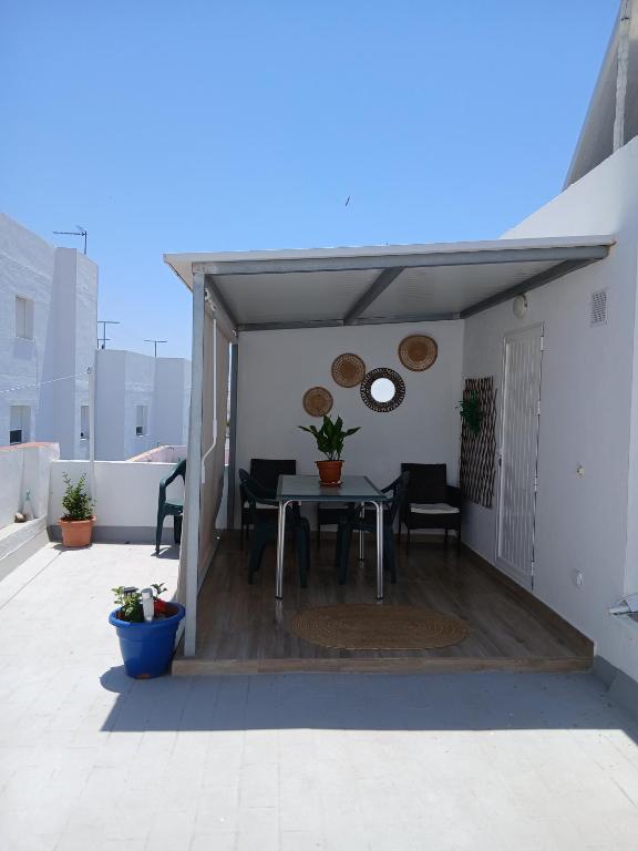 a patio with a table and chairs on a roof at Atico Juani in Conil de la Frontera