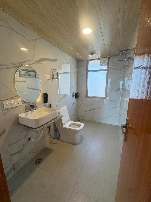a bathroom with a sink and a toilet and a mirror at The Snow Rock in Palchān