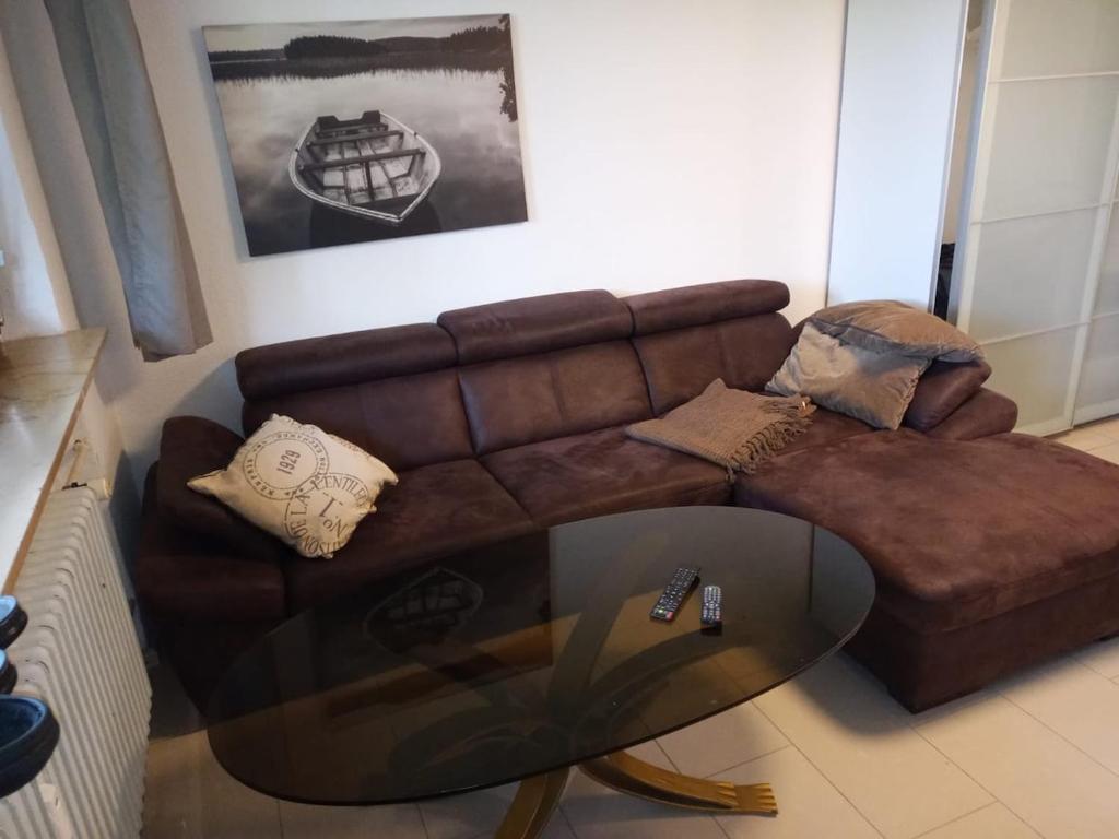 a living room with a brown couch and a glass table at Luki's Apartment in Horn-Bad Meinberg