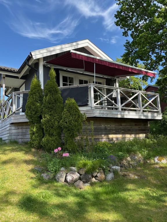 ein Haus mit einer Veranda an der Seite in der Unterkunft Toppstugan in Åkerö