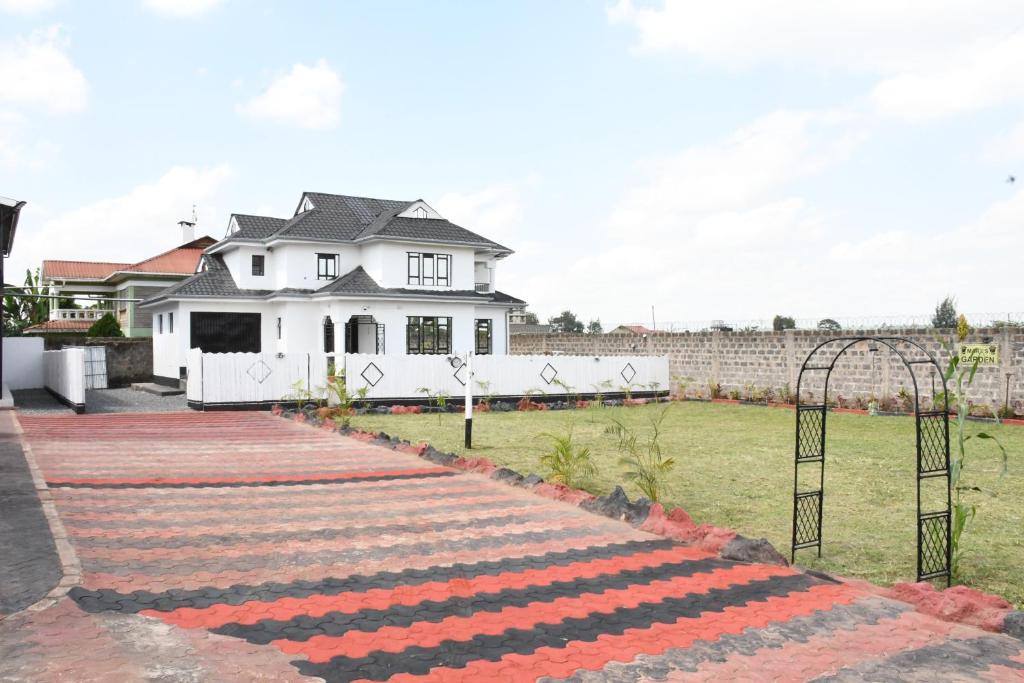 a walkway in front of a white house at Progressive Success Residency in Juja