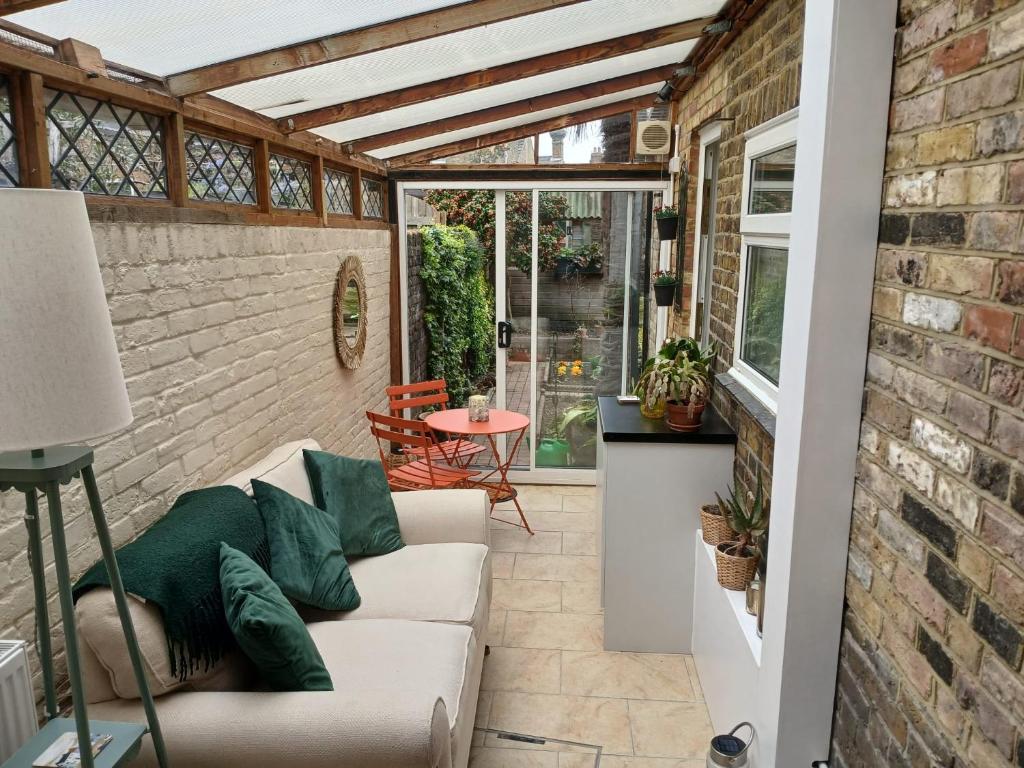 a living room with a white couch and a brick wall at Railmans Rest in Faversham