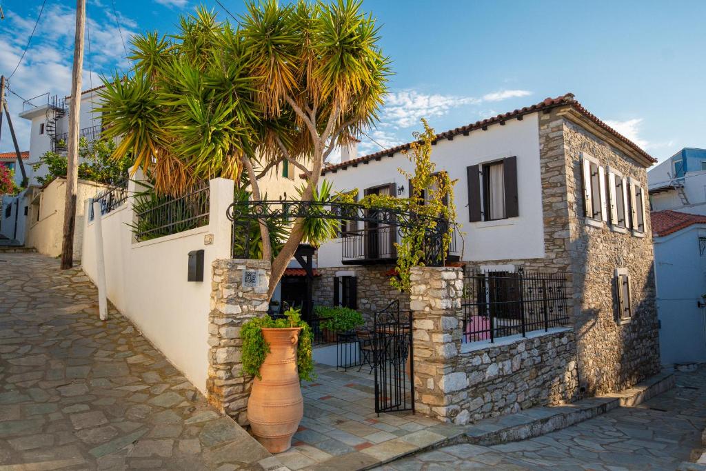 a building with a palm tree in front of it at The Dream House Skiathos in Skiathos